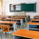 Modern classroom with chairs, desks, and chalkboard.